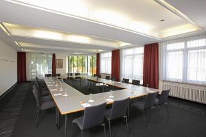 ein großer Konferenzraum mit einem langen Tisch und Stühlen in der Unterkunft Christkönigshaus in Stuttgart