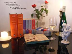 a table with books and a bottle of wine and a glass at Zum Achten Himmel in Klotten