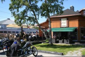 un grupo de motocicletas estacionadas frente a un edificio en Le Ski Lodge & Steakhouse en Storlien