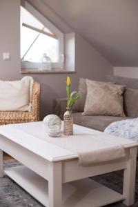 un tavolino bianco in soggiorno con divano di Ferienwohnung Sonnenblick a Zingst