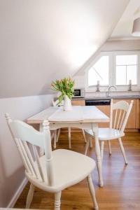 una sala da pranzo con tavolo e sedie e una cucina di Ferienwohnung Sonnenblick a Zingst