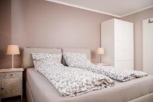 un letto con due cuscini e due lampade di Ferienwohnung Sonnenblick a Zingst