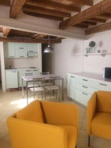een woonkamer met een gele bank en een tafel bij Casa Angiola in Cagli