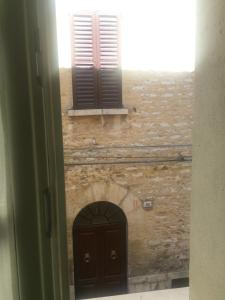 een deur en een bakstenen muur met twee ramen bij Casa Angiola in Cagli
