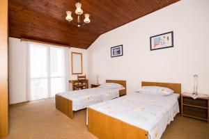 1 dormitorio con 2 camas y ventana en Apartment Srđ, en Dubrovnik