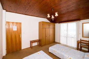 1 dormitorio con 2 camas y techo de madera en Apartment Srđ, en Dubrovnik