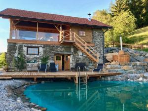 une cabane en rondins avec une terrasse et une piscine dans l'établissement Wohlfühloase Koglerhof, à Friesach