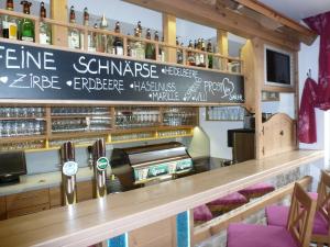 bar z napisem na ścianie z butelkami wina w obiekcie Der Sailer Hotel & Restaurant w mieście Obertauern