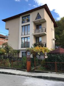 a large white house with a fence in front of it at Guest Rooms Profirov in Zlatograd