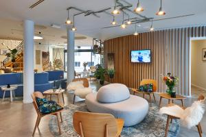eine Lobby mit einem Hut auf einem Tisch und Stühlen in der Unterkunft Hygge Hotel in Brüssel