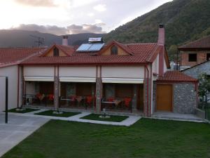 a house with a roof with a table and chairs at To Konaki in Kato Loutraki