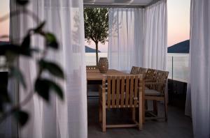 a table and chairs on a balcony with a view of the ocean at Palmon Bay Hotel & Spa in Herceg-Novi