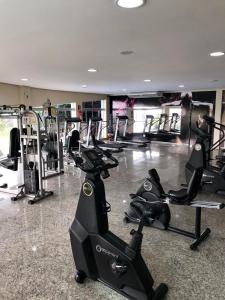 a gym with several treadmills and exercise bikes at Prime Hotel Águas da Serra in Rio Quente