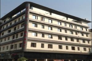 ein großes weißes Gebäude mit vielen Fenstern in der Unterkunft Hotel Vikrant in Ludhiana