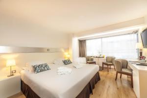 a hotel room with a large bed and a desk at Hôtel Montaigne & Spa - Cannes Centre in Cannes