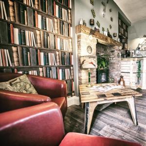 a living room with a table and bookshelves at The Elm Tree in Spilsby