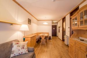 un salon avec un canapé et un bureau dans l'établissement Residence Edelweiss, à San Martino di Castrozza