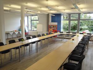 a conference room with long tables and chairs at A&S Ferienzentrum Schwerin in Schwerin