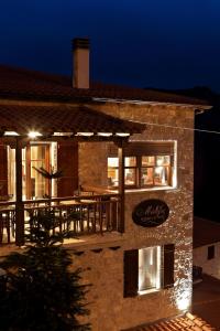 a brick building with a restaurant on it at night at Methexis Boutique Hotel in Dhimitsana