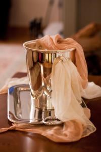 a silver cup sitting on a table with a towel at Methexis Boutique Hotel in Dhimitsana