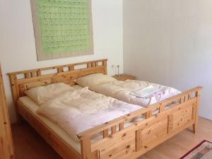 ein großes Holzbett in einem Zimmer mit in der Unterkunft FeWo "Eva" in Ostseebad Nienhagen