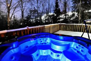 a blue hot tub in a yard with snow at Chalets Alpins- 05 Chemin Alpin in Stoneham