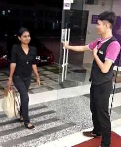a man and a woman standing in front of a glass door at Hotel Lavender Senawang in Seremban