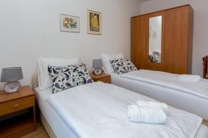 1 Schlafzimmer mit 2 Betten und einem Spiegel in der Unterkunft Apartmani Lito in Stobreč