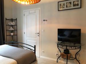 1 dormitorio con 1 cama y mesa con TV en Petit Appartement Jourdan EU, en Bruselas