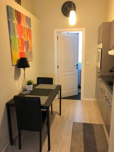 cocina y comedor con mesa y sillas en Petit Appartement Jourdan EU, en Bruselas