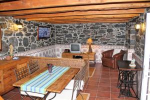 una sala de estar con una pared de piedra en OurMadeira - Stonecliff Cottage, countryside retreat, en Calheta