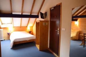 a bedroom with a bed and an open door at La Ferme du Bois Barbu in Villard-de-Lans