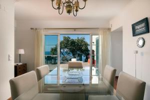 a dining room with a glass table and chairs at OurMadeira - Casa do Júlio, Calheta beach view in Calheta