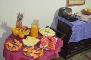 a table topped with plates of fruit and juice at Pousada Rancho da Mata in Conservatória