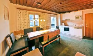 a kitchen with a wooden table and chairs and a counter at Haus Ennsblick in Flachau +7 photos