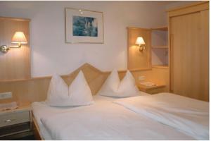 a bedroom with a bed with white pillows on it at Haus Ennsblick in Flachau