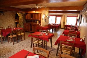 um restaurante com mesas vermelhas e cadeiras num quarto em La Ferme du Bois Barbu em Villard-de-Lans