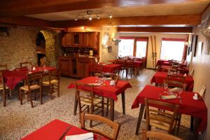 ein Restaurant mit roten Tischen und Stühlen in einem Zimmer in der Unterkunft La Ferme du Bois Barbu in Villard-de-Lans