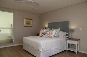 Un dormitorio con una cama blanca con almohadas. en Cape Coral, en Hermanus 6 fotos más