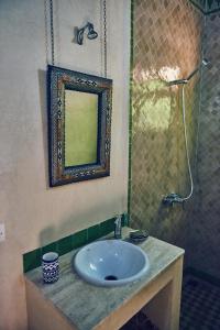 een badkamer met een wastafel, een spiegel en een douche bij Dar Saida in Fès