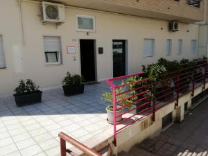 a building with a red railing and potted plants at Matera Sassi Rooms 21/a e 21/b in Matera