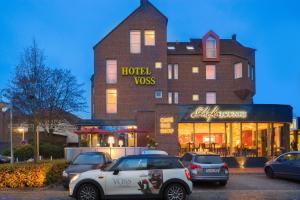 a building with cars parked in front of a store at Das Schokoladenhotel in Westerstede