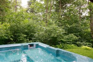 a swimming pool with a chair in a yard at Chalets Alpins -41 Chemin des Skieurs in Stoneham