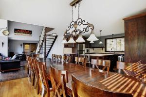 a dining room with a large wooden table and chairs at Chalet 01 Chemin Blanc by Les Chalets Alpins in Stoneham