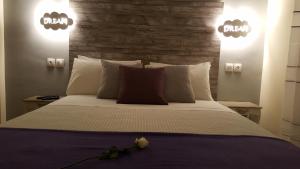 a bedroom with a large bed with two lights at City Space Apartments in Giannitsa