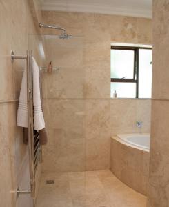 a bathroom with a shower and a tub and a sink at Keren's Vine Guesthouse in Stellenbosch