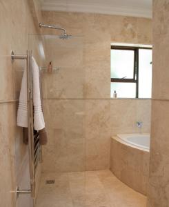 La salle de bains est pourvue d'une douche, d'une baignoire et d'un lavabo. dans l'établissement Keren's Vine Guesthouse, à Stellenbosch