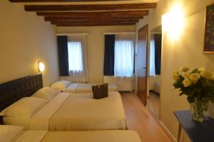 une chambre d'hôtel avec deux lits et un canapé dans l'établissement Piccolo Tiepolo, à Venise