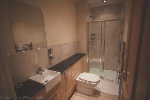uma casa de banho com um chuveiro, um WC e um lavatório. em Apartment B em Aberdeen