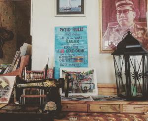 a table with a sewing machine and a poster on a wall at Kunyit 7 Lodge in Bandar Seri Begawan